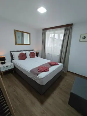 a bedroom with a large bed and a window at Апартаменти Белчини in Dobrinishte