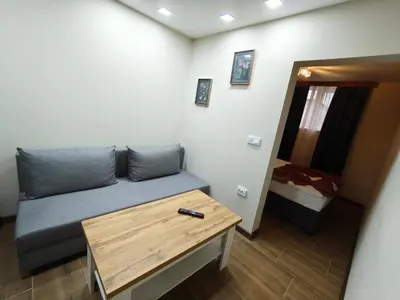 a living room with a couch and a table at Апартаменти Белчини in Dobrinishte