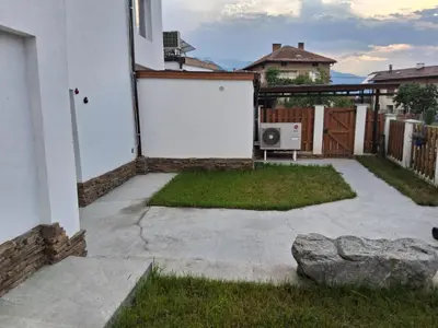 a backyard with a white door and a fence at Апартаменти Белчини in Dobrinishte