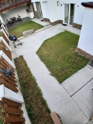 a backyard with a patio and grass at Апартаменти Белчини in Dobrinishte