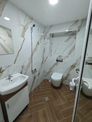 a bathroom with a sink and a toilet at Апартаменти Белчини in Dobrinishte