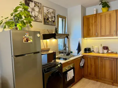 a kitchen with a stainless steel refrigerator and a dishwasher at 2-room Forest Retreat - Fireplace, Veranda, BBQ, Views in Bansko