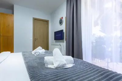 a bedroom with a bed with towels on it at 2-room Forest Retreat - Fireplace, Veranda, BBQ, Views in Bansko