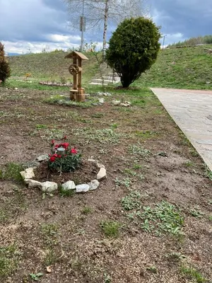 a garden with a flower bed in the middle of a yard at 2-room Forest Retreat - Fireplace, Veranda, BBQ, Views in Bansko