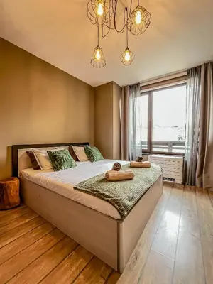 a bedroom with a large bed and a large window at Tarein Studio in Bansko
