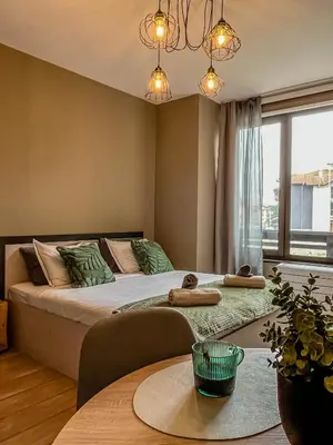 a bedroom with a large bed and a table at Tarein Studio in Bansko