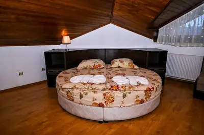 a bedroom with a large bed with towels on it at Хотел Валентино 2 in Dobrinishte