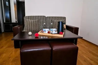a brown leather chair with a coffee table and a couch at Хотел Валентино 2 in Dobrinishte
