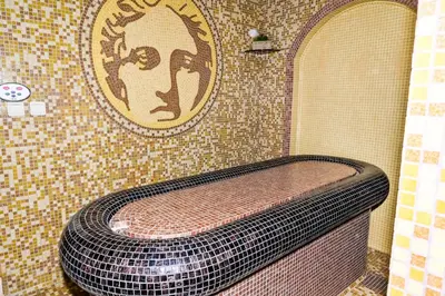 a tiled bathroom with a toilet in a shower at Хотел Валентино 2 in Dobrinishte