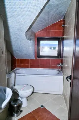 a bathroom with a tub and a toilet and a sink at Хотел Валентино 2 in Dobrinishte