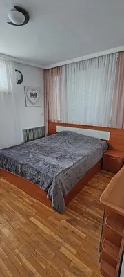 a bedroom with a bed and a wooden floor at Апартамент Sofia View in Sofia