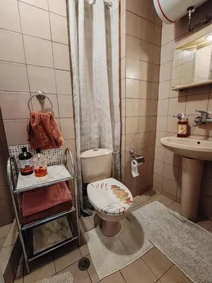 a bathroom with a toilet and a sink at Апартамент Sofia View in Sofia