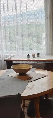a bowl on top of a wooden table in front of a window at Апартамент Sofia View in Sofia