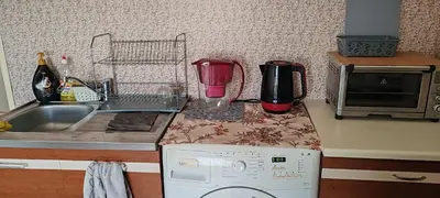 a kitchen counter with a sink and a washing machine at Апартамент Sofia View in Sofia