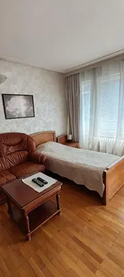 a bedroom with a bed and a couch and a table at Апартамент Sofia View in Sofia