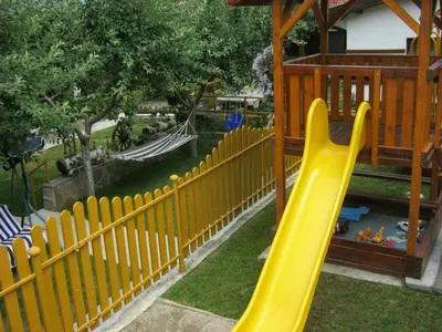 a yellow fence next to a playground with a slide at Лазов in Sapareva Banya