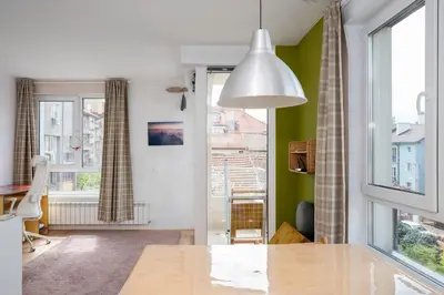 a living room with a table and a window at Bright and Cozy 1BD Apartment plus Desk by Flat Mаnаger in Sofia