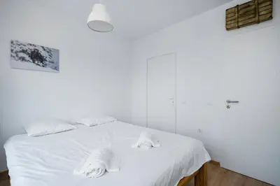 a bedroom with a white bed with towels on it at Bright and Cozy 1BD Apartment plus Desk by Flat Mаnаger in Sofia