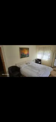 a bedroom with a white bed and a painting on the wall at Macedonia55 in Sandanski