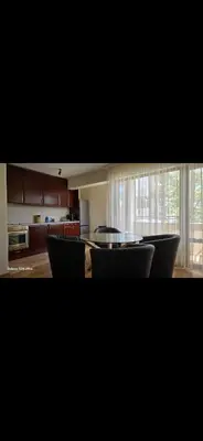 a living room with a table and chairs and a kitchen at Macedonia55 in Sandanski