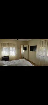 a bedroom with a bed and two windows at Macedonia55 in Sandanski