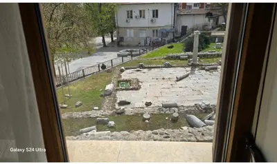 a window with a view of a stone courtyard at Macedonia55 in Sandanski