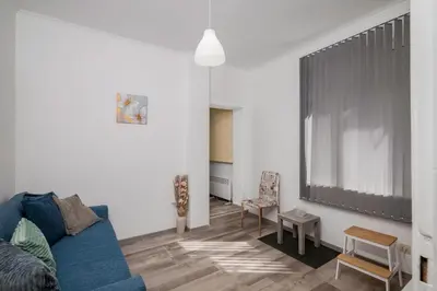 a living room with a blue couch and a table at Central 1BD Next to Womens Market and Sofia's Gems by Flat Mаnаger in Sofia