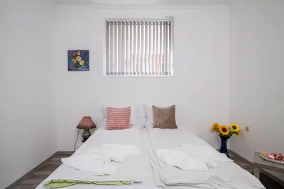 a bedroom with a bed with white sheets and a window at Central 1BD Next to Womens Market and Sofia's Gems by Flat Mаnаger in Sofia