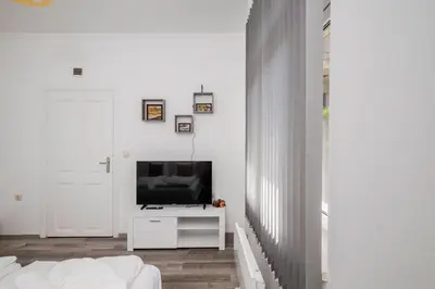 a living room with a television on a white table at Central 1BD Next to Womens Market and Sofia's Gems by Flat Mаnаger in Sofia