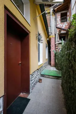 an alley with a red door next to a building at Central 1BD Next to Womens Market and Sofia's Gems by Flat Mаnаger in Sofia