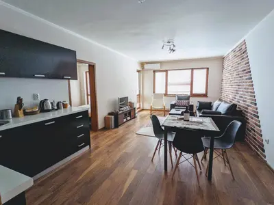 a living room with a table and chairs and a living room at Spacious modern 1BR apartment near the gondola in Bansko