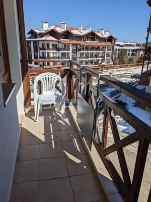 a balcony with a white chair on a building at Spacious modern 1BR apartment near the gondola in Bansko