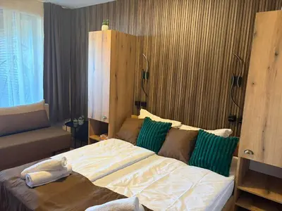 a bedroom with a large bed with green pillows at Апартаменти Pamporovo Dream в Гранд Ризорт Пампорово in Pamporovo