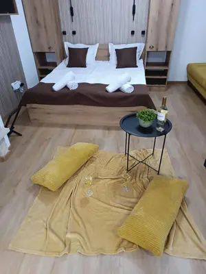 a bedroom with a large bed with a table and yellow pillows at Апартаменти Pamporovo Dream в Гранд Ризорт Пампорово in Pamporovo