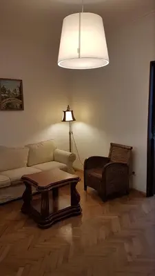 a living room with a couch and a table and a lamp at Elegant and cozy apartment in Sofia