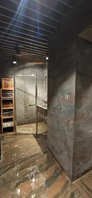 a bathroom with a shower and a stone wall at Elegant and cozy apartment in Sofia