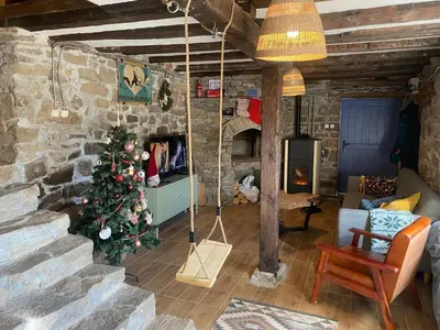a living room with a christmas tree in a stone wall at Ta Petrina Cottage in Selishte