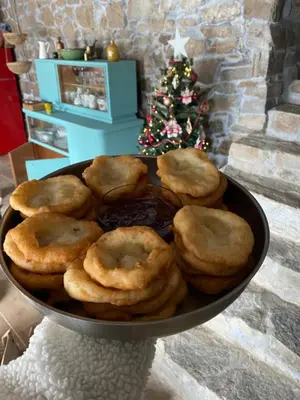 a bowl of donuts in front of a christmas tree at Ta Petrina Cottage in Selishte