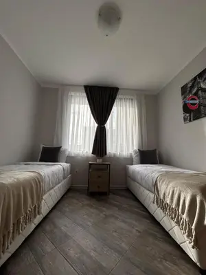 two beds in a room with a window at Tanov Cozy Place in Blagoevgrad