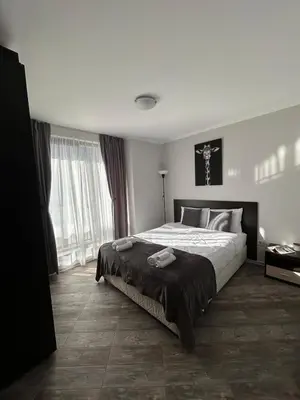 a bedroom with a large bed and a large window at Tanov Cozy Place in Blagoevgrad