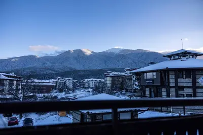 a snow covered city with mountains in the background at Flat in Bansko 5m walk to gondola in Bansko