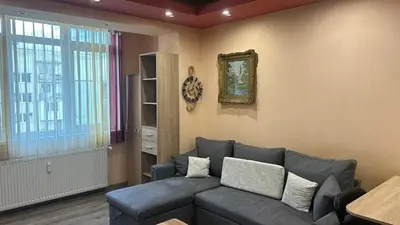 a living room with a gray couch and a window at Heart of Pernik apartment 2 in Pernik