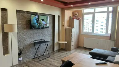a living room with a tv on a brick wall at Heart of Pernik apartment 2 in Pernik