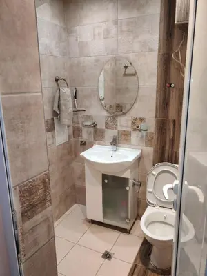 a bathroom with a toilet and a sink and a mirror at Heart of Pernik apartment 2 in Pernik