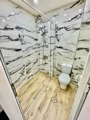 a bathroom with a toilet and marble walls at MK Studios Krustova Vada plus Parking!!! in Sofia