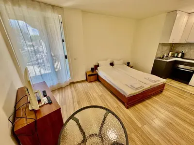 a bedroom with a bed and a table and a chair at MK Studios Krustova Vada plus Parking!!! in Sofia