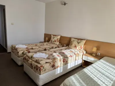 a hotel room with two beds and a bedskirts at Хотел Добринище in Dobrinishte