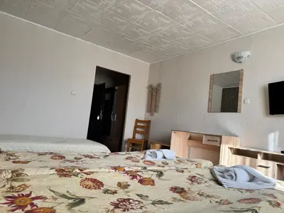 a hotel room with two beds and a tv at Хотел Добринище in Dobrinishte