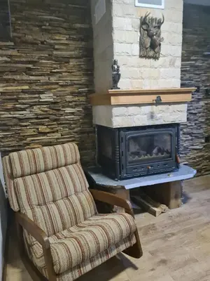 a living room with a chair and a fireplace at Къща за гости Джерман Guest house Dzherman in Sapareva Banya