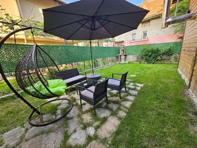 a hammock with chairs and a table and an umbrella at Къща за гости Джерман Guest house Dzherman in Sapareva Banya